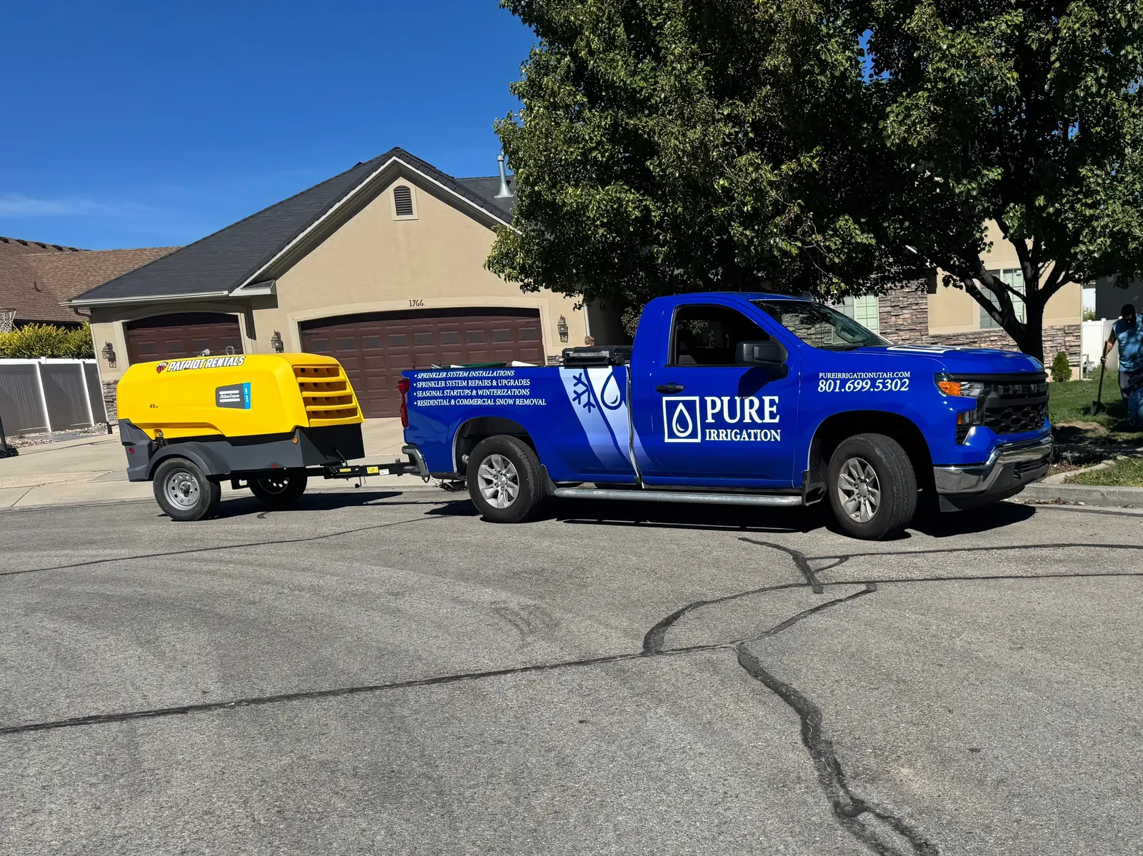 A Pure Irrigation truck towing an air compressor for sprinkler winterization